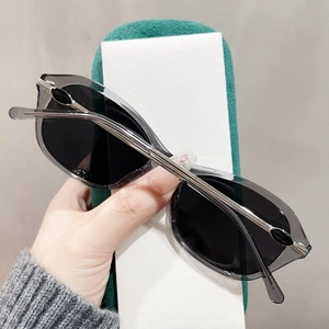 Detail einer grauen Cat-Eye-Sonnenbrille mit silbernen Metallscharnieren und Gläsern