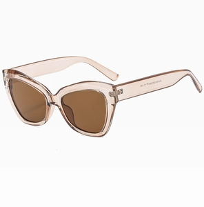 Macro detail of cat-eye sunglasses with translucent champagne frame and brown lenses