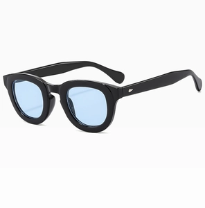 Detail view of black frame sunglasses with light blue lenses and arrow metal hinges