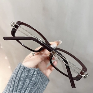 Detailed shot of dark red square frames with hollow silver metal temples on hand
