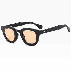Detail view of vintage black square frame sunglasses with orange lenses and silver rivets
