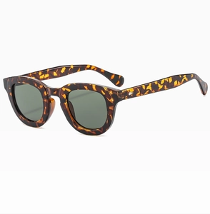 Detailed side view of tortoise shell sunglasses with metal rivets and green lenses