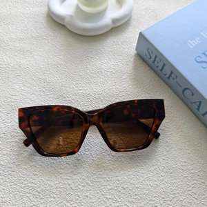 Détail de lunettes de soleil œil de chat écaillé sur plateau avec accessoires de style