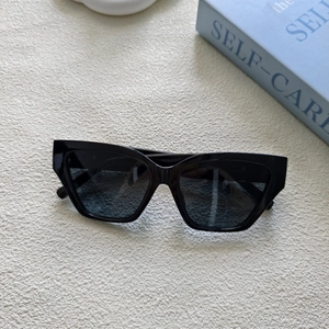 Détail de lunettes de soleil œil de chat noires avec monture rectangulaire sur décor