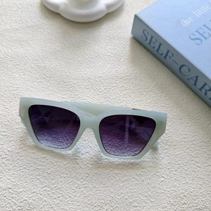 Détail de lunettes de soleil vert menthe mat avec verres dégradés violets sur tissu