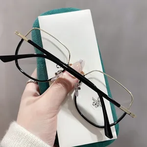 Détail de lunettes anti-lumière bleue avec monture en métal doré près d'un étui en velours