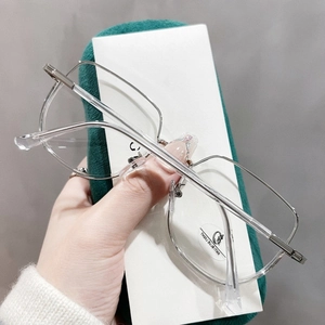 Détail de lunettes anti-lumière bleue en métal argenté avec une pochette en velours