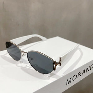 Detail of retro cat-eye sunglasses featuring white acetate temples and silver metal frames