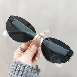 Detail of vintage cat-eye sunglasses featuring silver metal frames and dark grey lenses