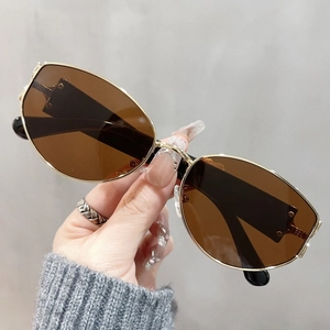 Close-up of stylish gold metal frame sunglasses with brown lenses and wide temples