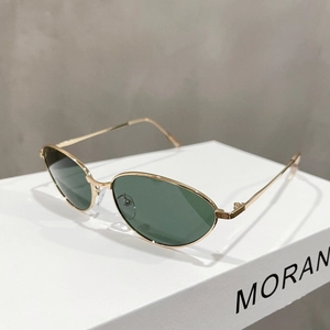 Detail of vintage gold metal cat-eye sunglasses with green lenses on a display box