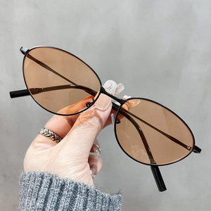 Close-up of vintage cat-eye sunglasses with thin black metal frame and light brown lenses