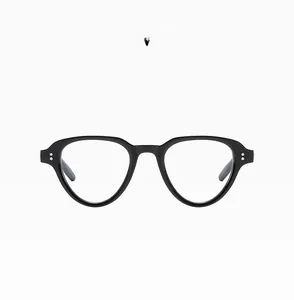 Detail view of glossy black vintage sunglasses with silver rivets and blue light lenses