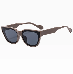 Detail view of stylish dark brown cat-eye sunglasses with thick glossy frames and dark lenses