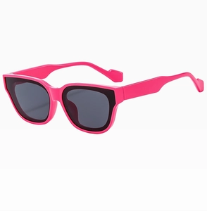 Detail view of hot pink and black stylish sunglasses with dark grey UV protective lenses