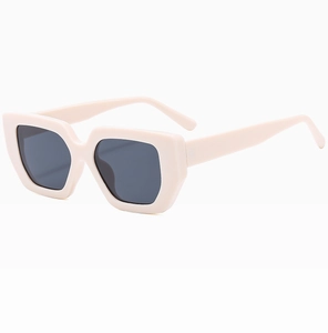 Dettaglio occhiali da sole squadrati oversize crema con lenti grigio scuro UV