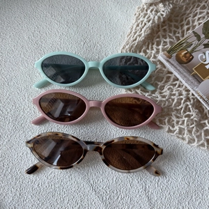 Three-piece set of vintage oval sunglasses in mint green, pale pink, and leopard tortoise