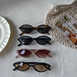 Retro oval sunglasses in leopard and solid colors displayed on white fabric backdrop