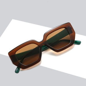 Occhiali da sole vintage marrone traslucido con montatura irregolare su supporto bianco