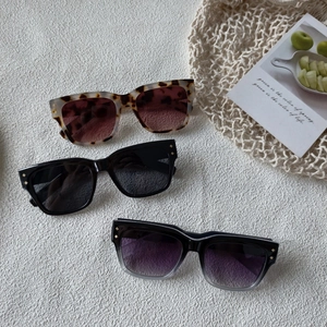 Quadratische Nietensonnenbrille in Leopard, Schwarz und Verlaufsoptik auf weißem Grund