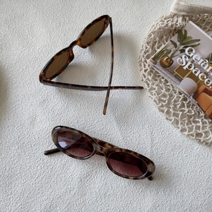 Détail de lunettes de soleil rondes en écaille avec verres dégradés sur fond tricoté