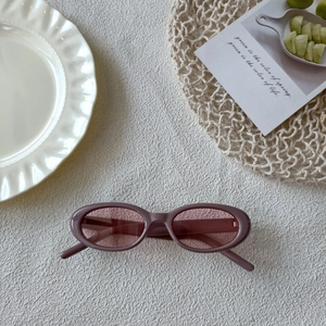 Détail de lunettes de soleil ovales vintage avec monture rose poudré et verres roses