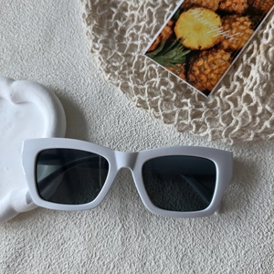 Polygonale Sonnenbrille mit weißem dickem Rahmen auf minimalistischem Sommer-Hintergrund