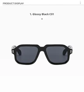 Detail of glossy black square sunglasses with grey lenses and silver hinge accents
