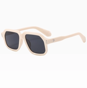 Detail view of cream oversized retro sunglasses with silver stud rivets and grey lenses