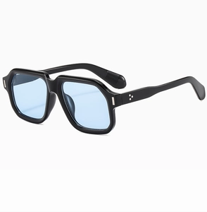 Close-up of retro black oversized frame with light blue lenses and silver rivet details