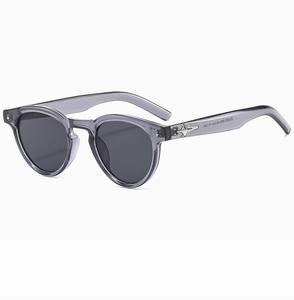 Detail view of oval sunglasses featuring transparent grey frames and star hinges