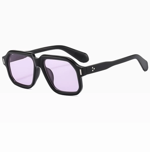 Detail view of square black thick frame sunglasses with purple tinted lenses and silver studs