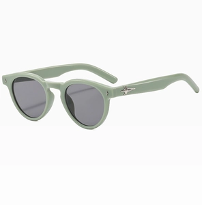 Detail of light green oval sunglasses with silver star accents and grey lenses