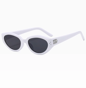 Detail view of oval sunglasses with white frames and silver metal hardware accents