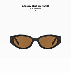 Detail view of oval sunglasses with bright black frame and brown lenses with metal rivets