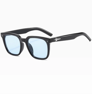 Detail of square black frame sunglasses with light blue lenses and silver star accents