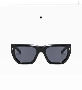 Front view detail of oversized black frame sunglasses with gray lenses and gold accents