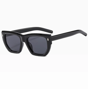 Macro detail of glossy black polygon sunglasses frame with silver metal rivets