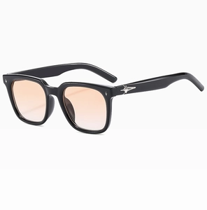 Detail of black square sunglasses with orange gradient lenses and silver star hardware