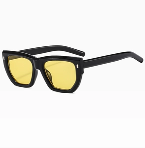 Detailed close-up of retro black frame sunglasses with yellow lenses and silver rivets