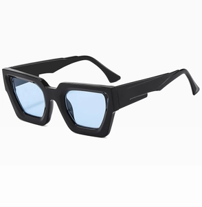 Detailaufnahme einer klobigen schwarzen quadratischen Sonnenbrille mit hellblauen Gläsern