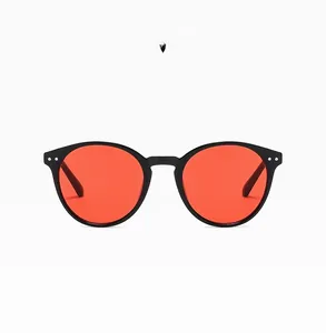 Retro-Rundsonnenbrille in Schwarz mit roten Gläsern und metallischen Nieten im Detail