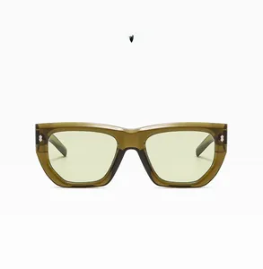 Detailed close-up of olive green polygon sunglasses with metal hinges and clear lenses