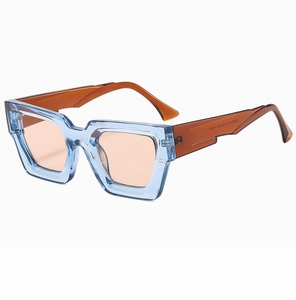 Detailansicht der markanten blauen transparenten quadratischen Sonnenbrille mit Bernsteinbügeln