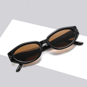 Retro oval sunglasses with black frames and metal rivet accents in a minimalist style