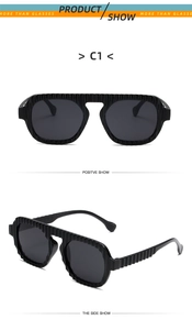 Detail view of black oversized sunglasses with unique vertical wavy texture on frames