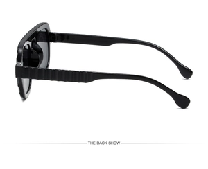 Detail view of the back of large frame sunglasses with wavy textured wide temples