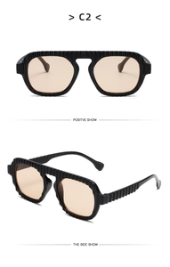 Detail of vintage square sunglasses featuring black ribbed frames and light tan lenses