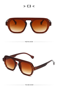 Macro view of C3 sunglasses featuring brown ribbed frames and gradient lenses