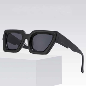 Lunettes de soleil carrées rétro avec monture noire épaisse sur une plateforme blanche